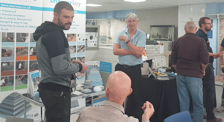 Image of a group of people attending a trade day event, networking and discussing business at Tile and Stone Gallery